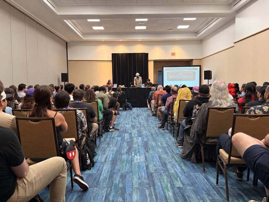 Packed convention room watching Brian's panel with an Audience Activity: Claim Denied slide on screen