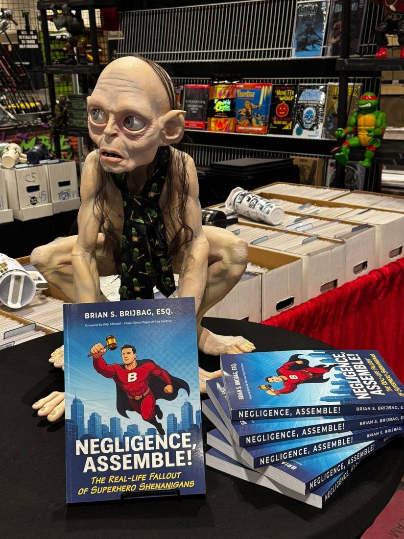 Negligence, Assemble! books displayed at a convention table